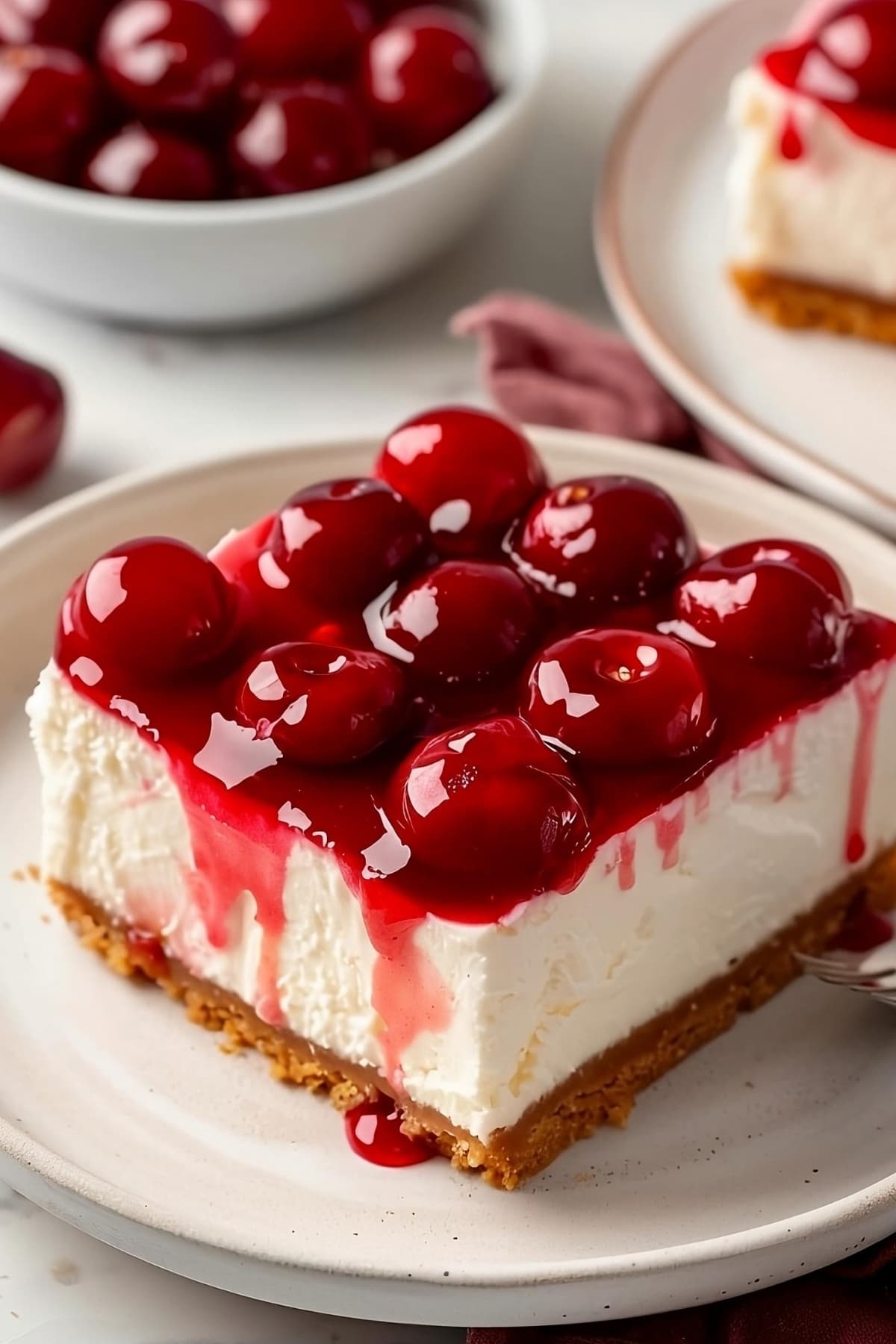 Slice of creamy cherry delight on a white plate.