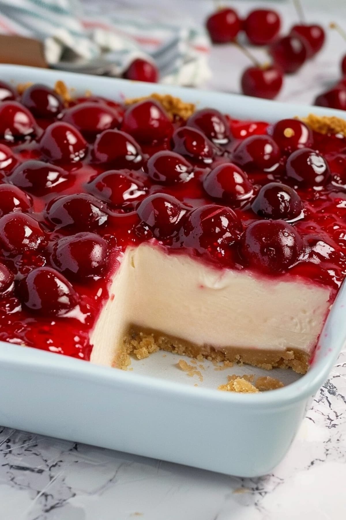 Cherry delight dessert in a baking dish with a slice missing
