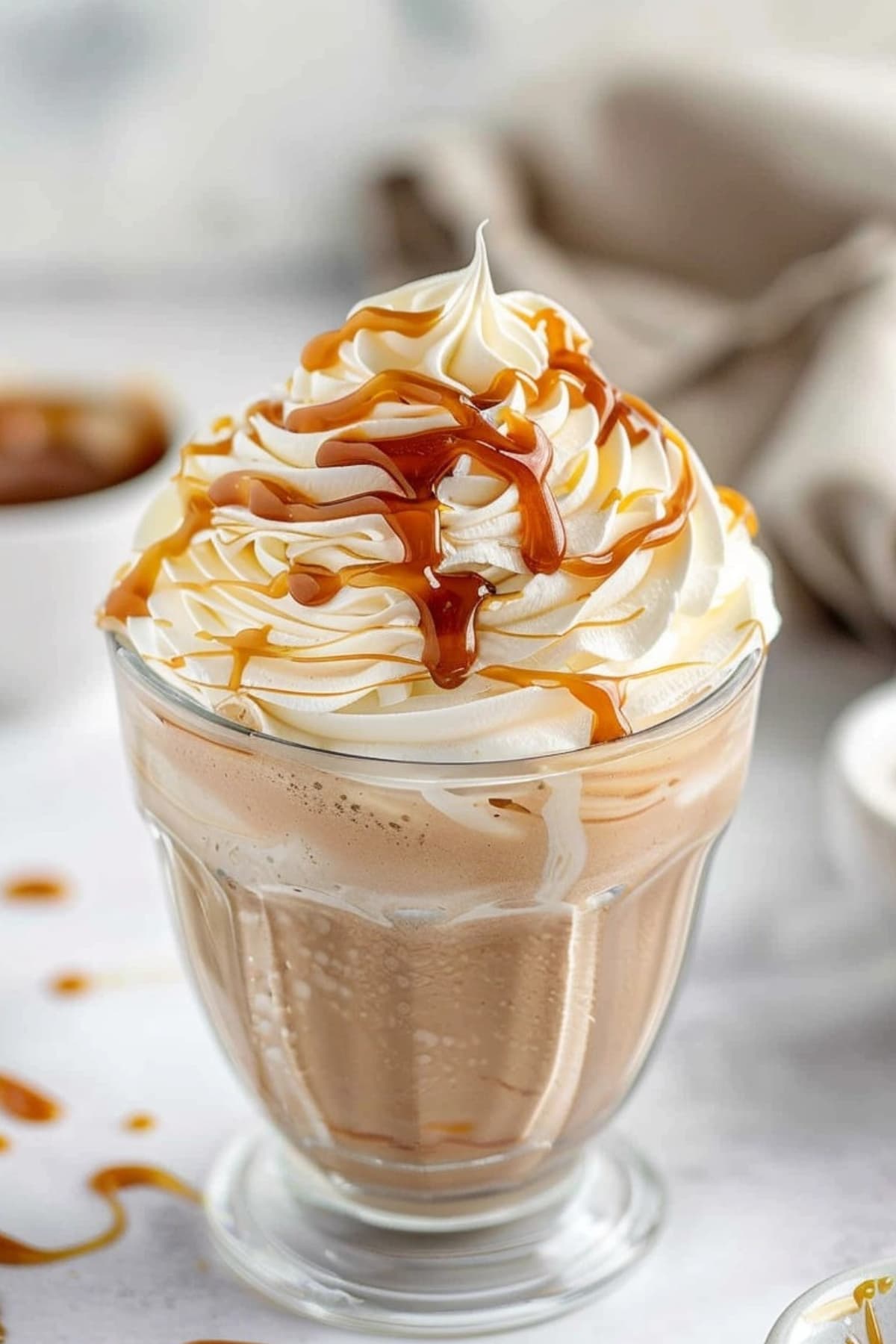 Chocolate milkshake topped with whipped cream drizzled with caramel syrup.