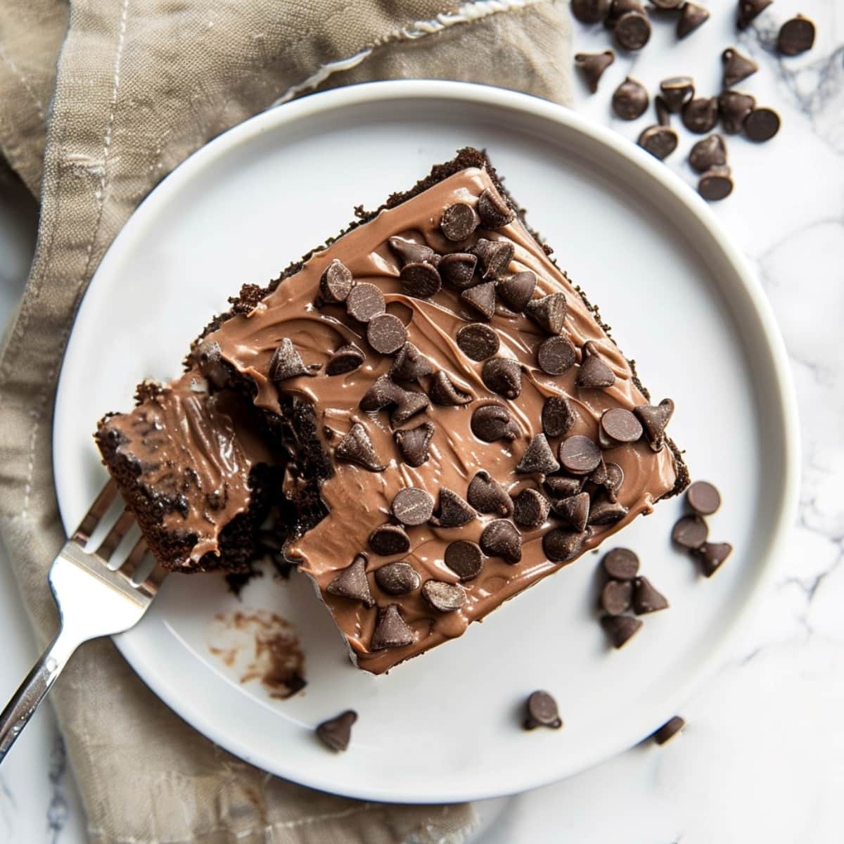 Creamy and decadent chocolate poke cake topped with chocolate chips