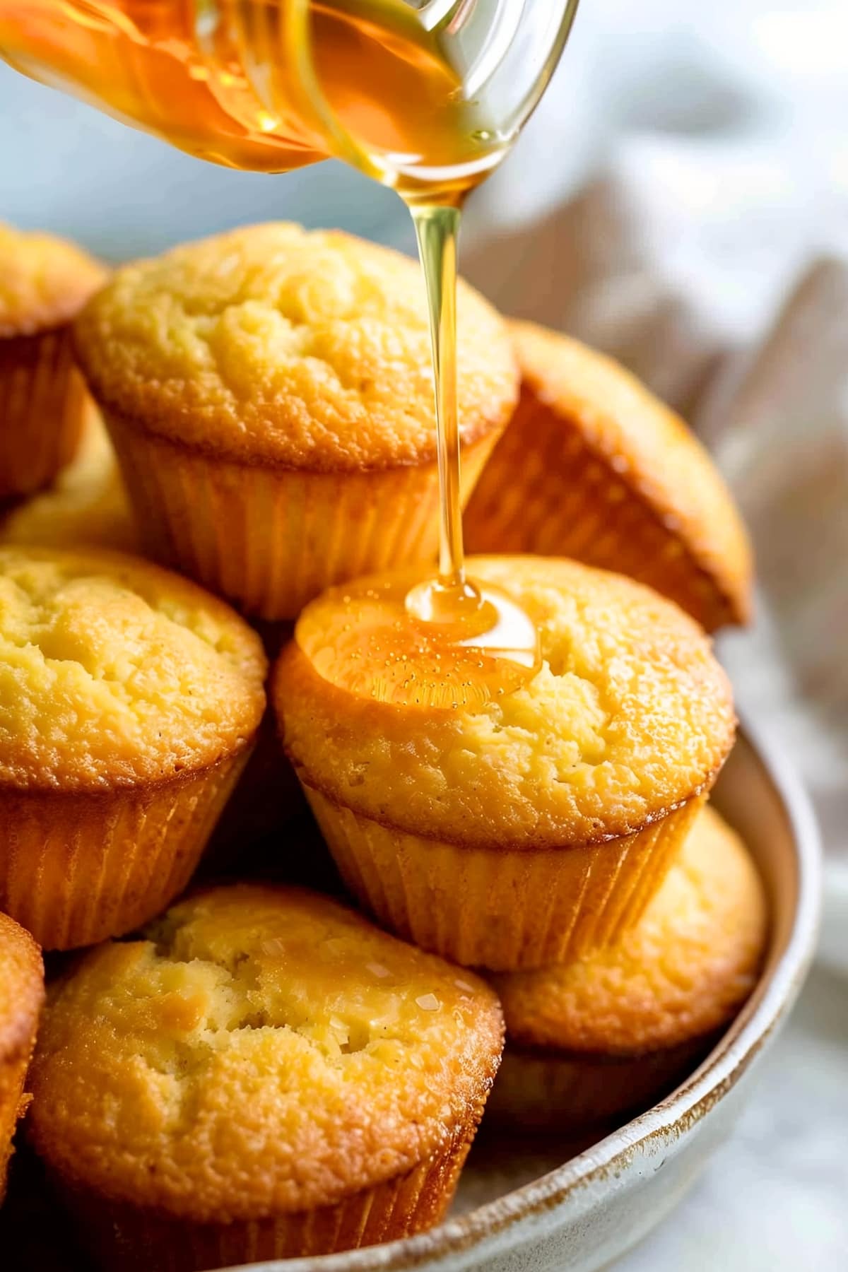 Honey being pourend into a cornbread muffins
