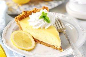 A delightful treat of sweet lemon icebox pie with graham crust in a plate