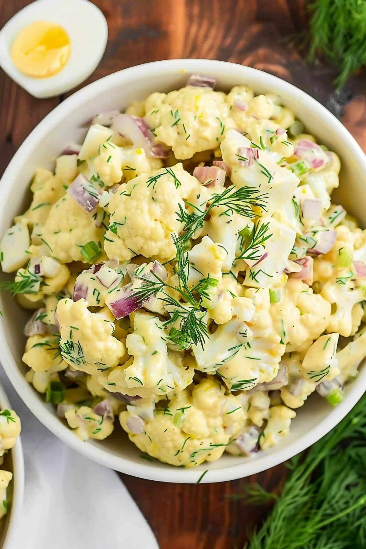 Creamy homemade cauliflower potato salad with red onions, dill and hard boiled eggs