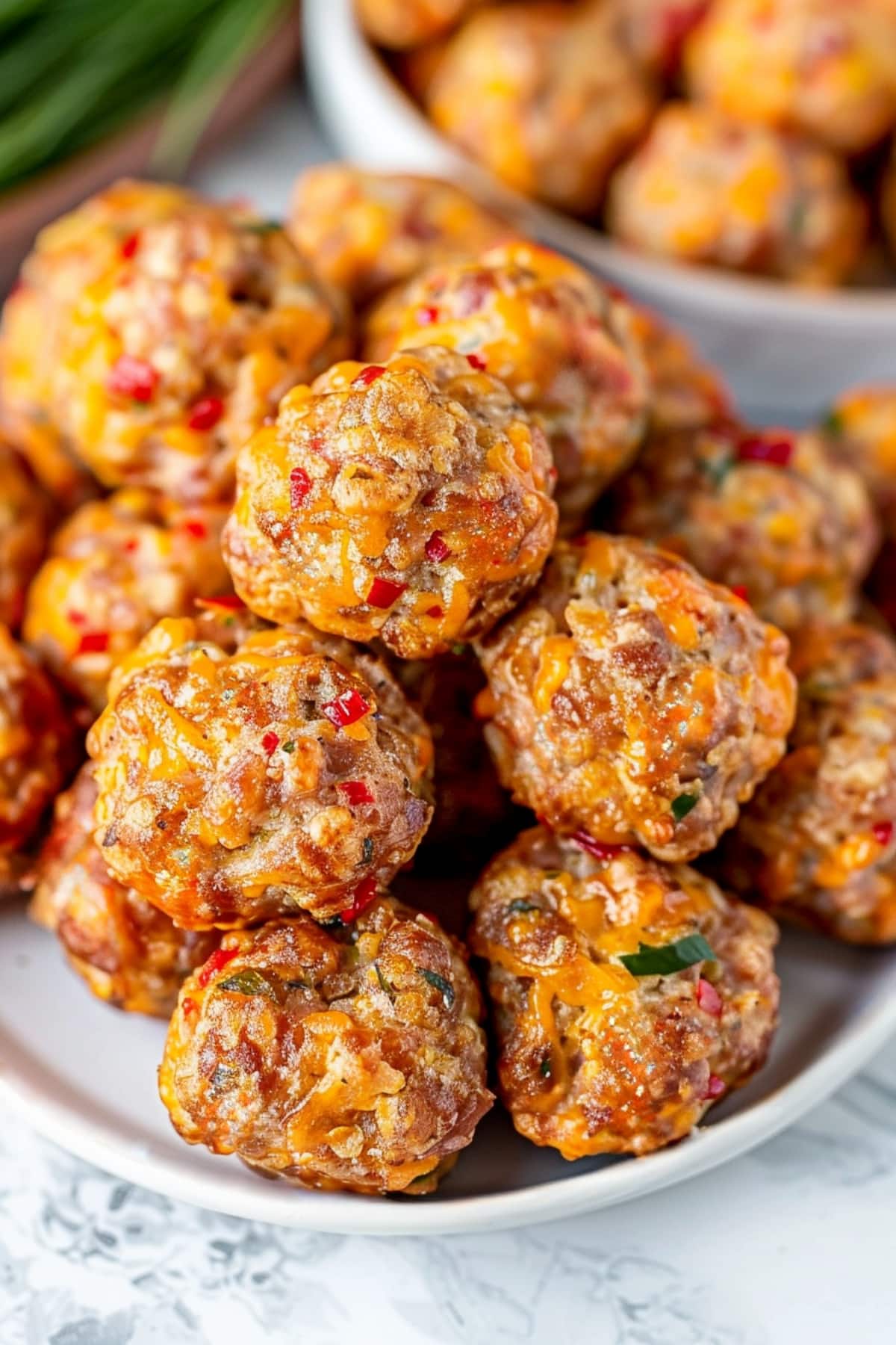 Bite-sized cheesy and a little spicy homemade pimento cheese sausage balls in a plate