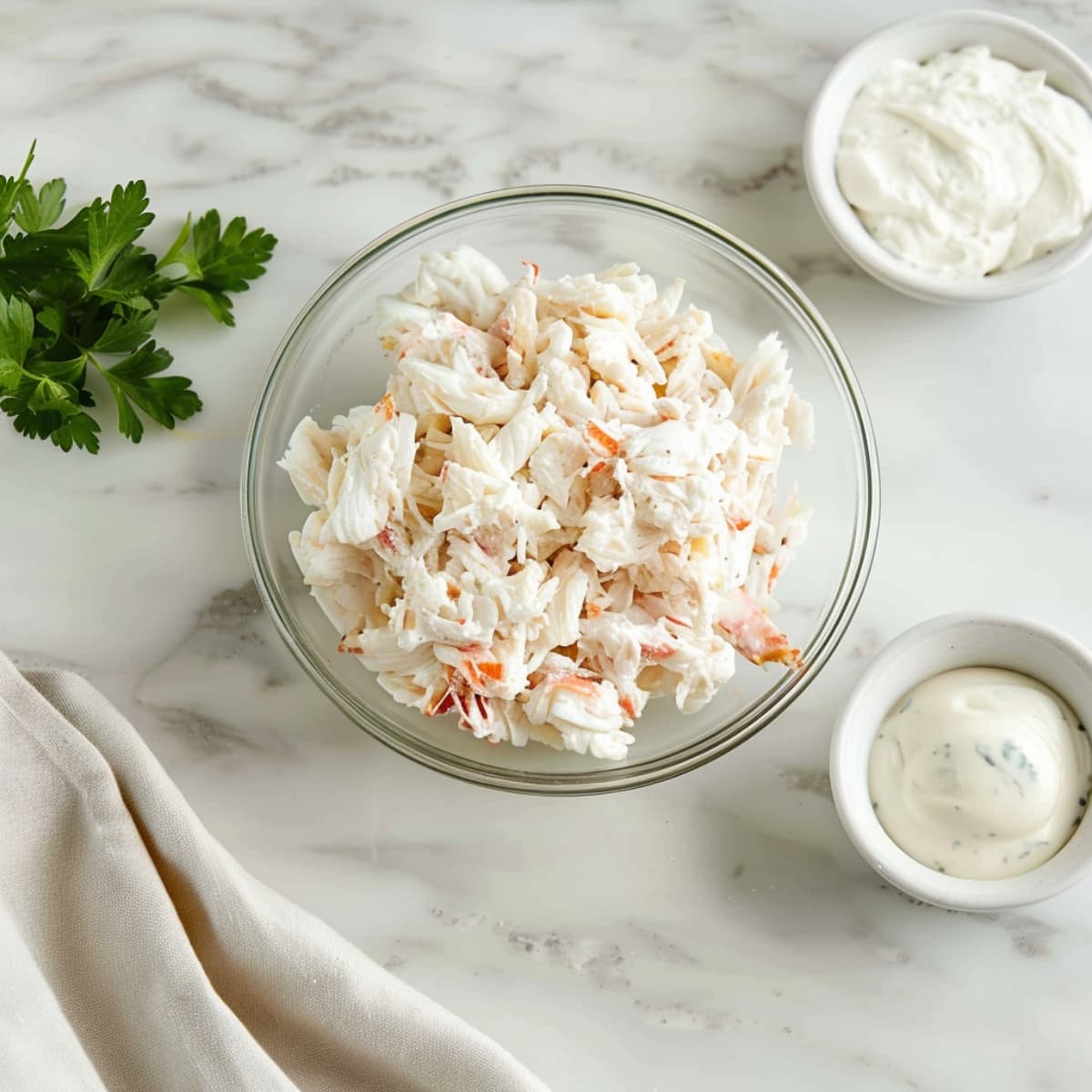 A glass bowl of lump crab meat with sour cream and cream cheese