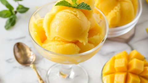 Homemade cold and refreshing mango sorbet in a glass with mint