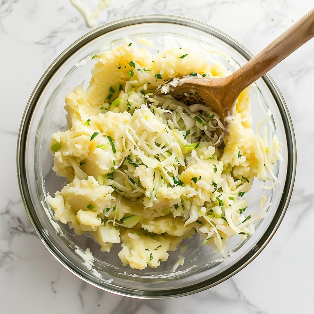 Mashed potato and cabbage mixture in a glass bowl.
