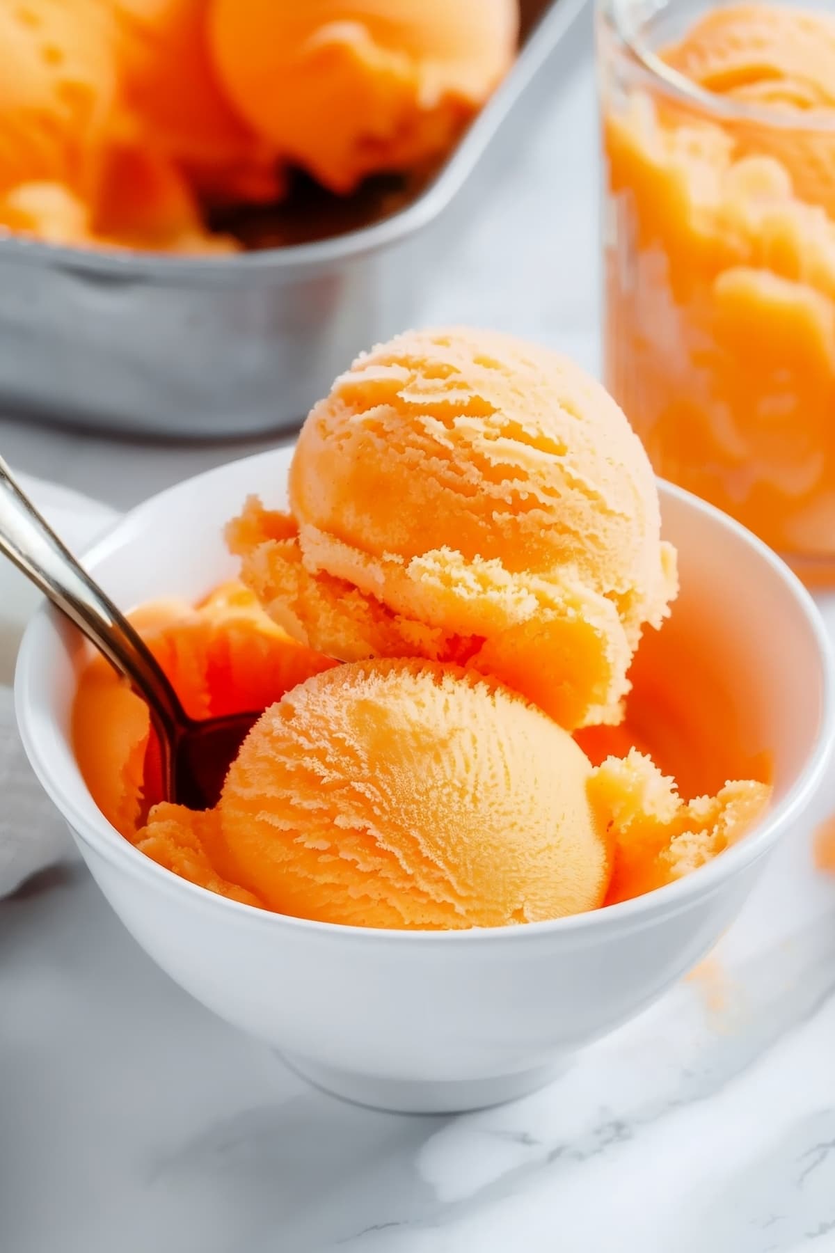 Scoops of homemade orange sorbet in a bowl