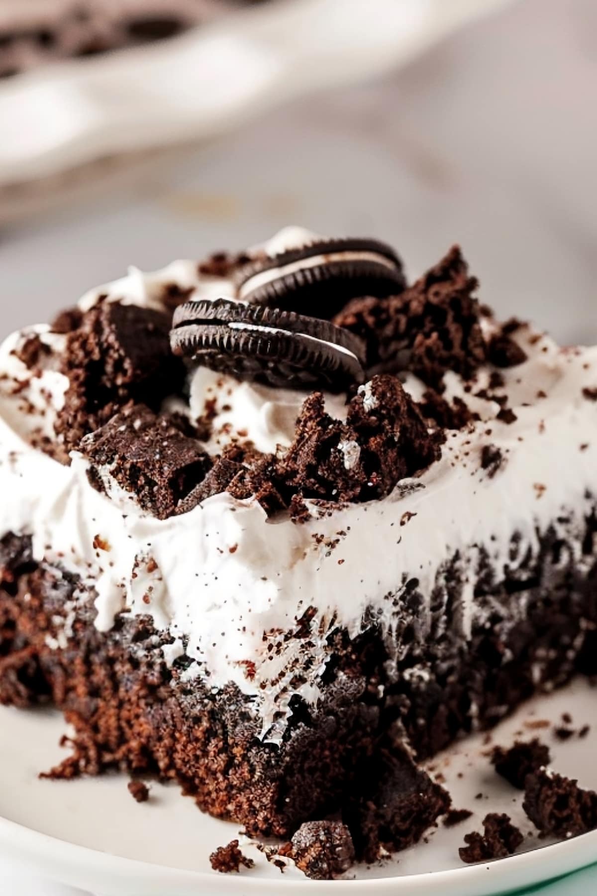 Close-up shot of oreo chocolate poke cake with whipped topping
