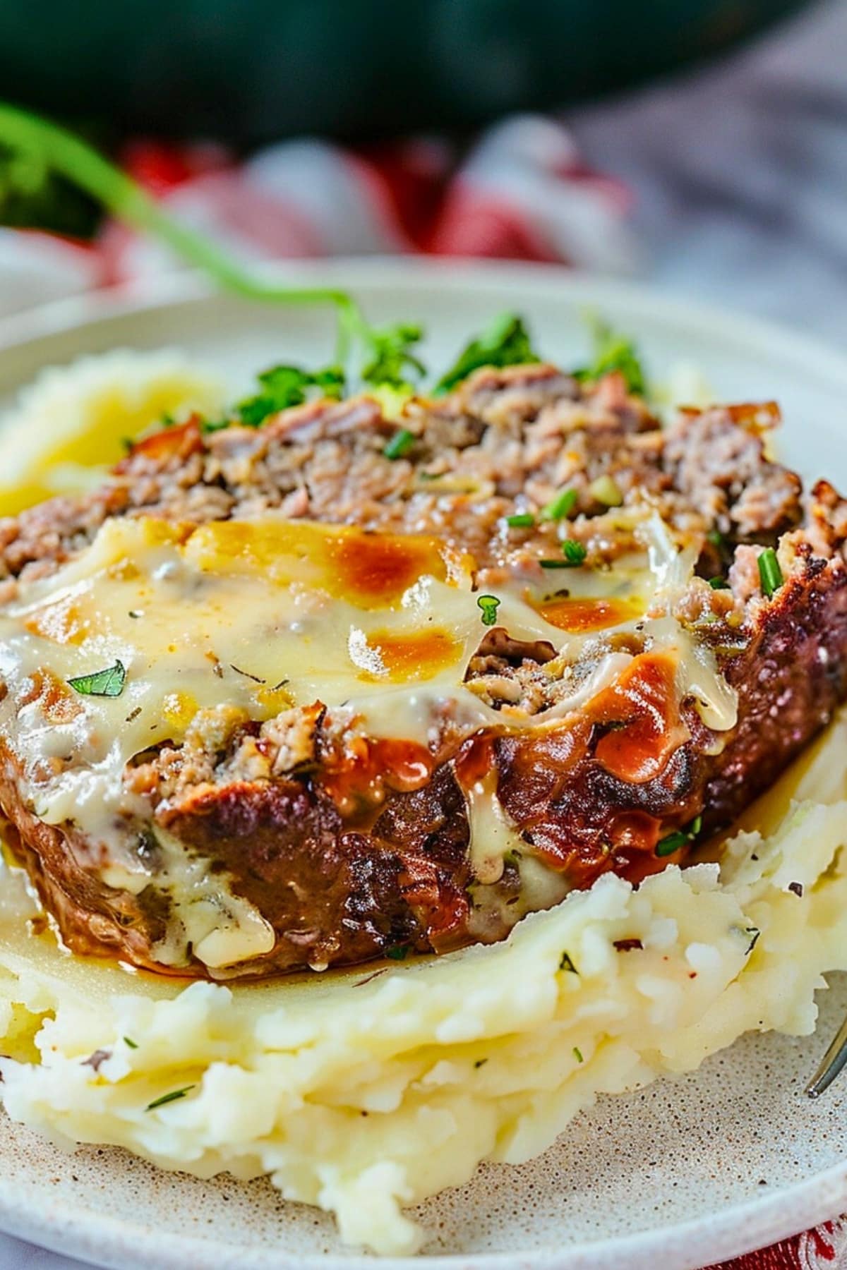 Philly Cheesesteak Meatloaf slice topped on mashed potato.