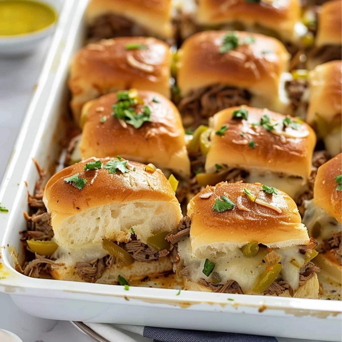 Pulled Philly Cheesesteak Sliders in a baking dish.