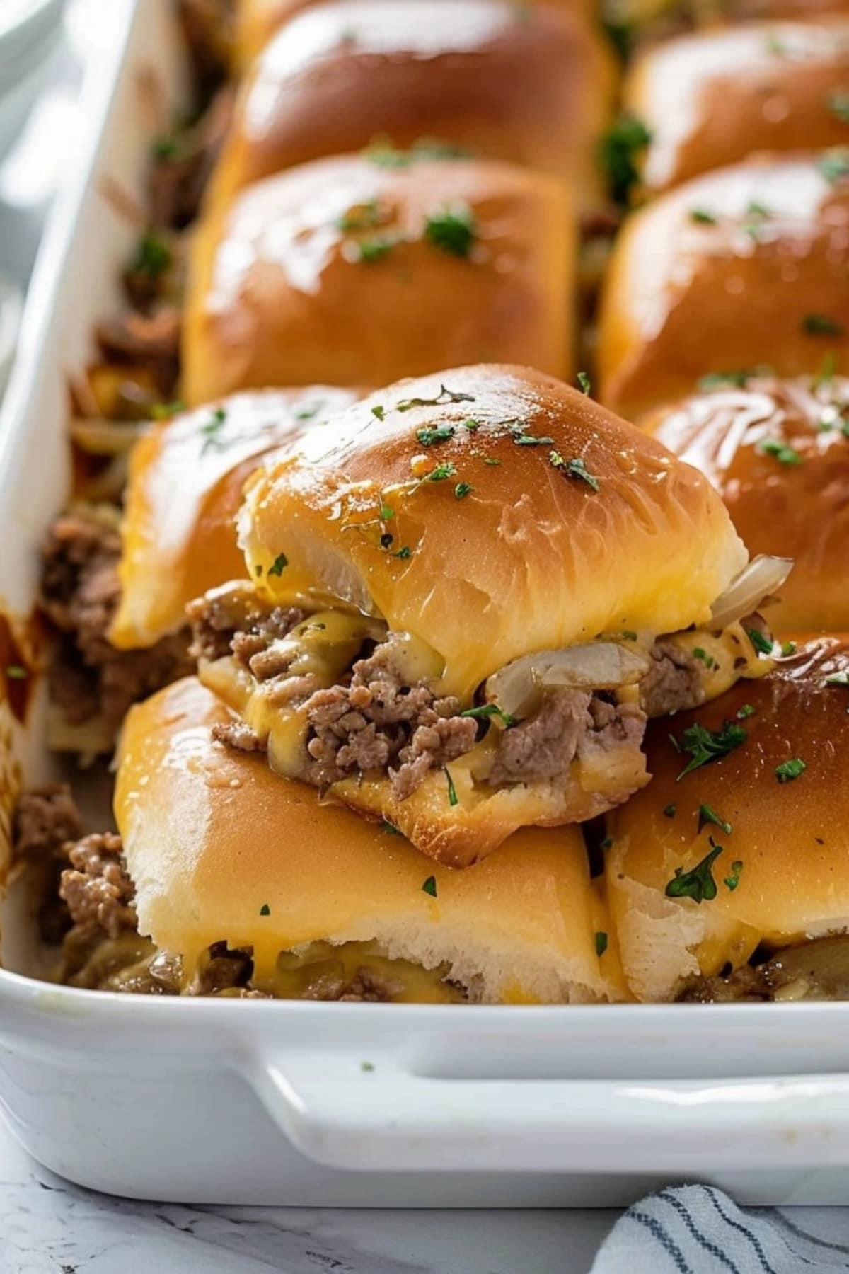 Philly Cheesesteak Sliders in a white baking dish.