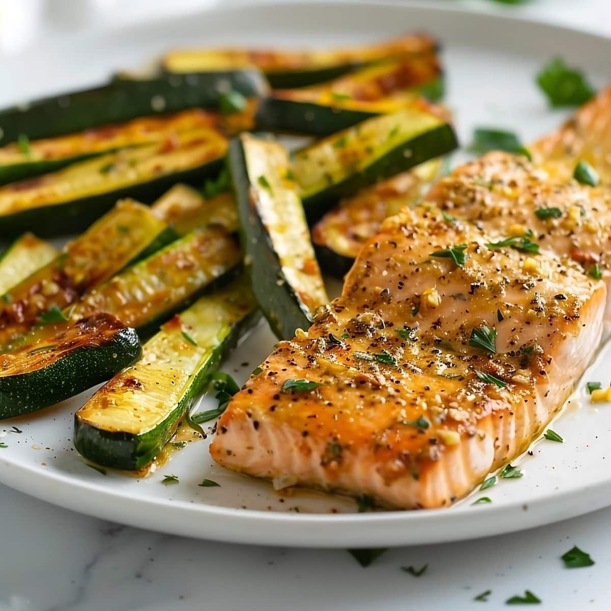 Slice baked salmon served with roasted zucchini sticks.