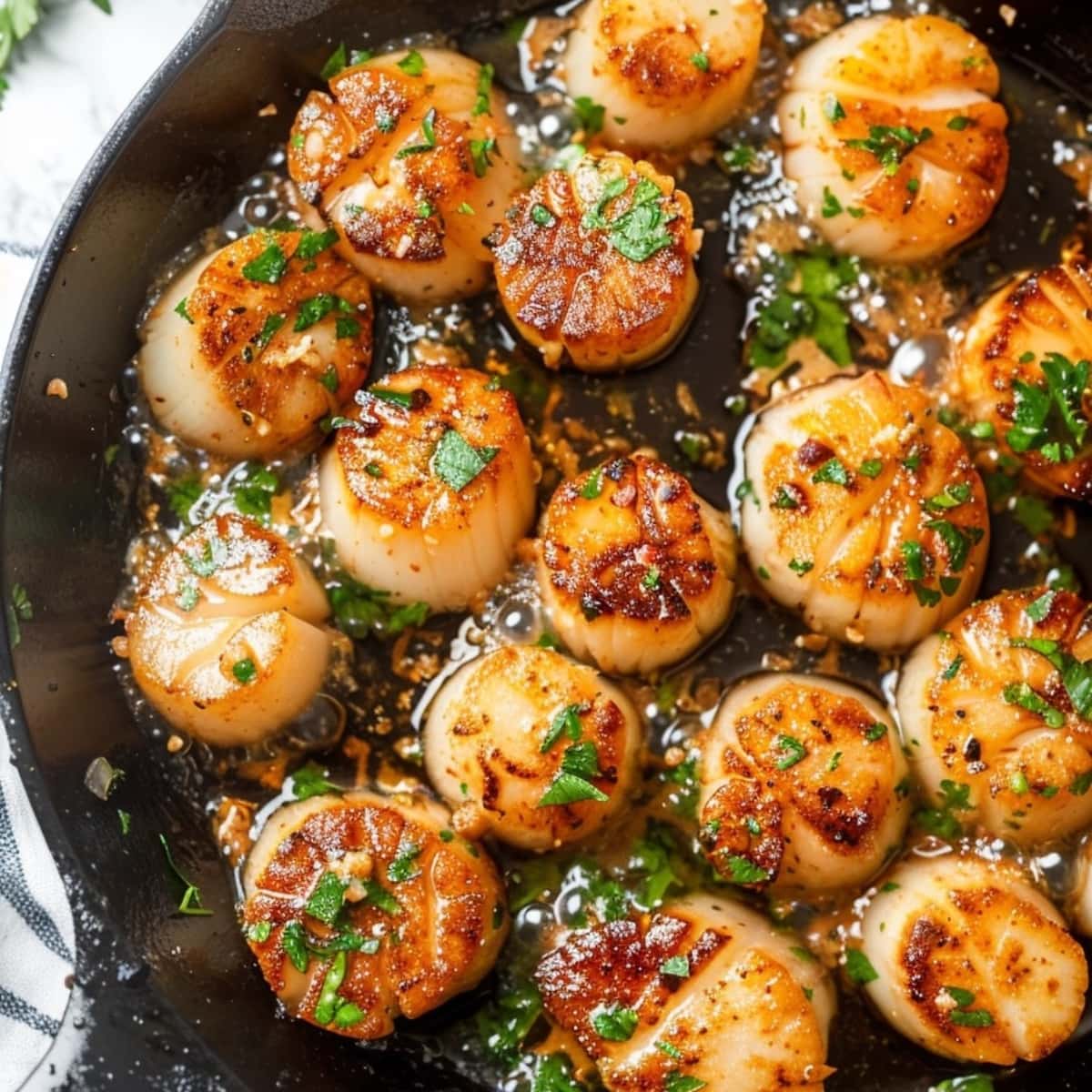 Air fried scallops tossed in garlic butter in cast iron skillet.