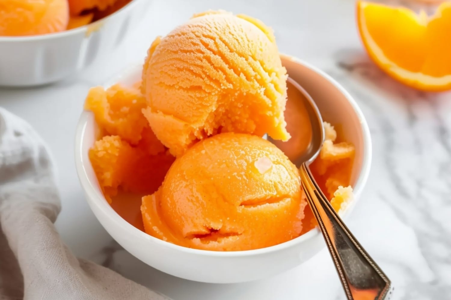 Creamy and citrusy homemade orange sorbet in a white bowl