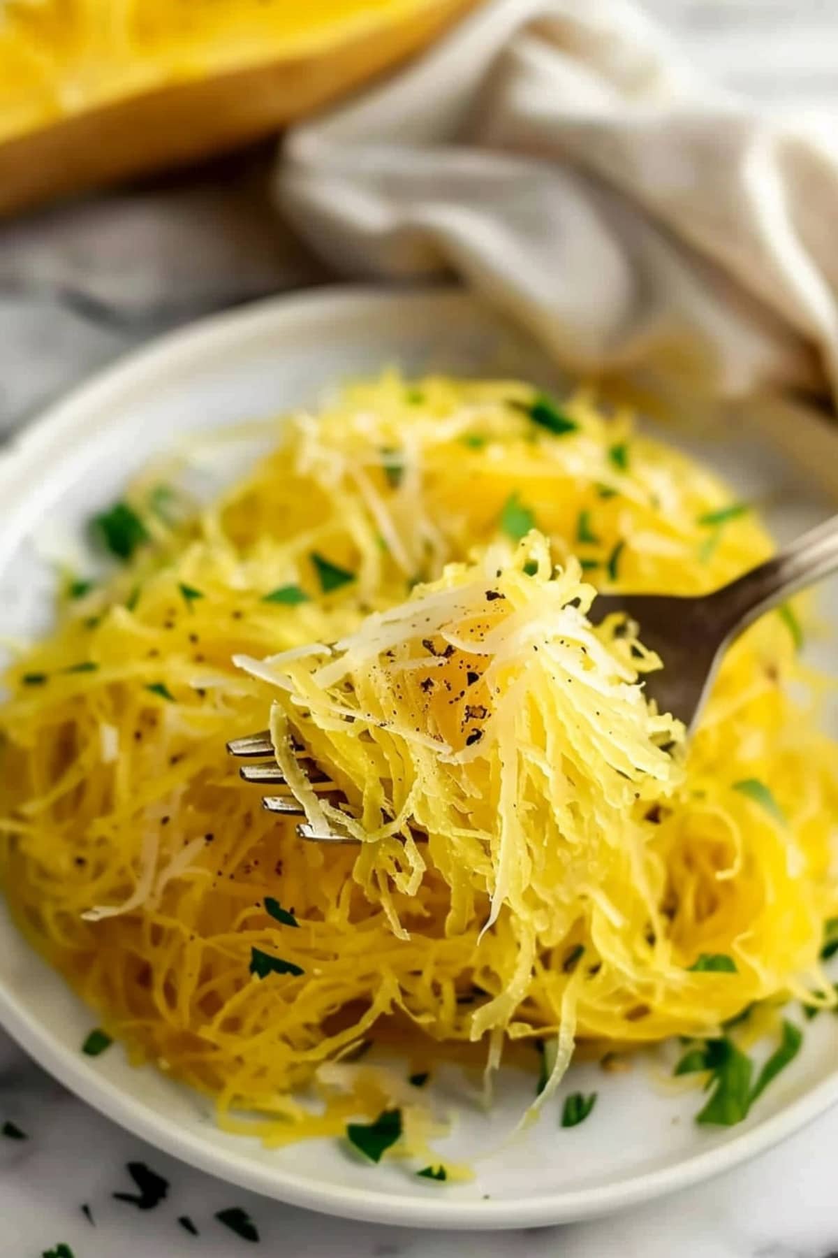 Shredded air fried spaghetti squash in for served on a white plate.