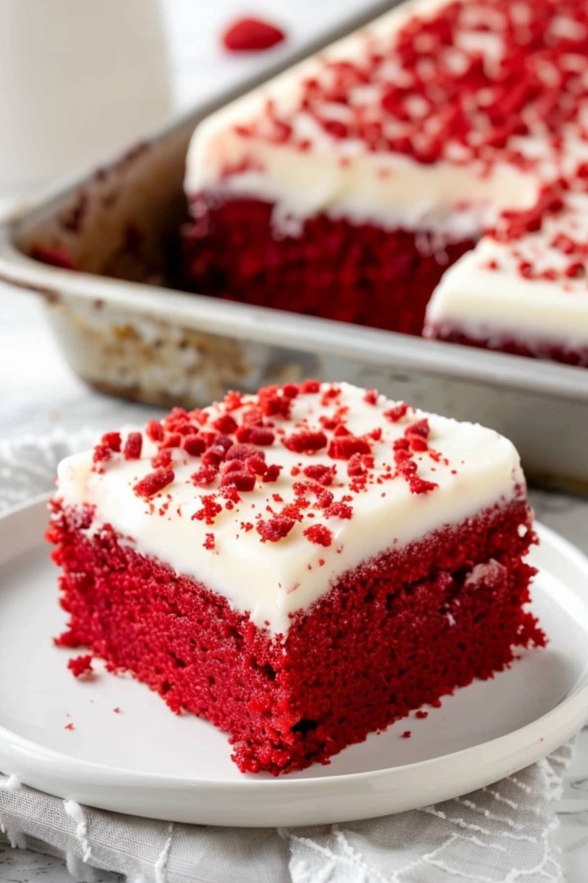 Slice of red velvet sheet cake in a white plate.