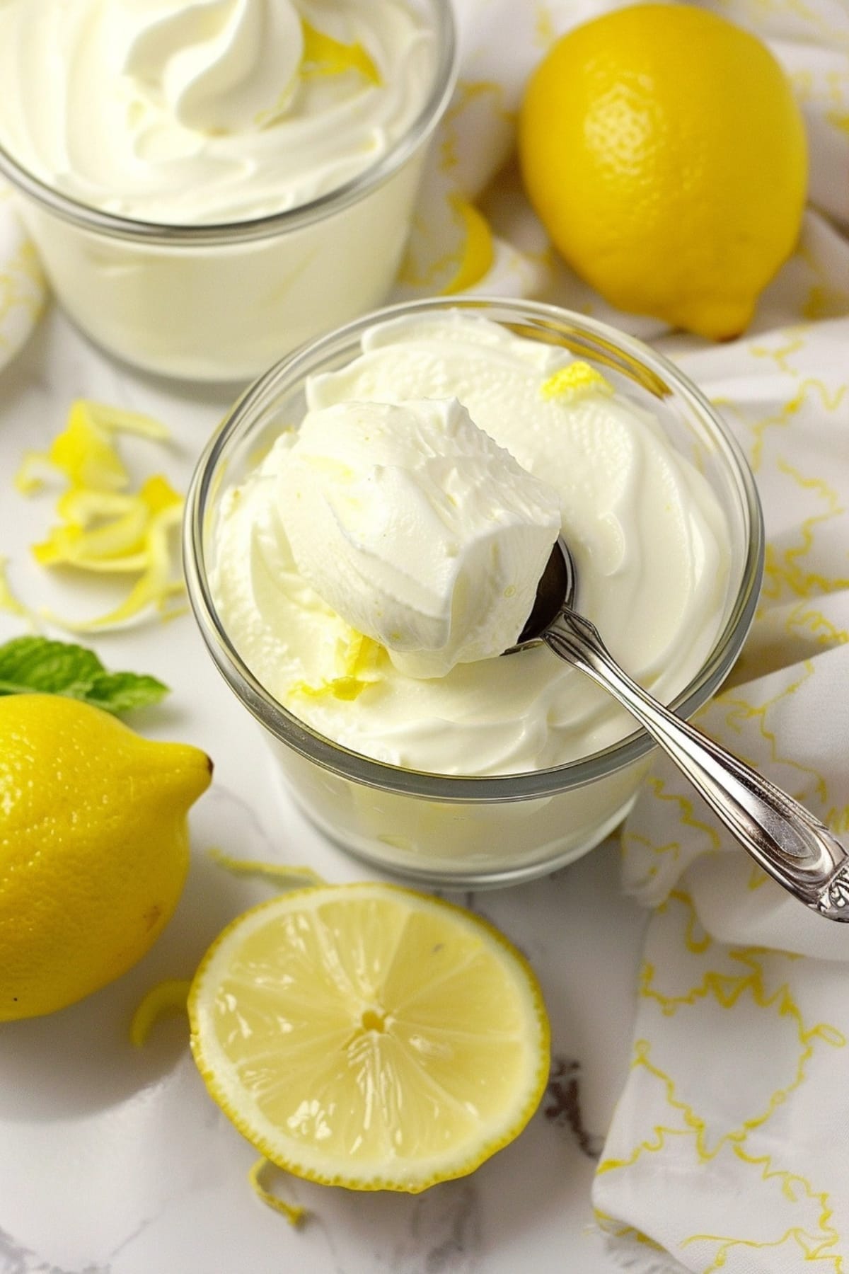 Small spoon scooping fluffy lemon mousse on a serving glass.