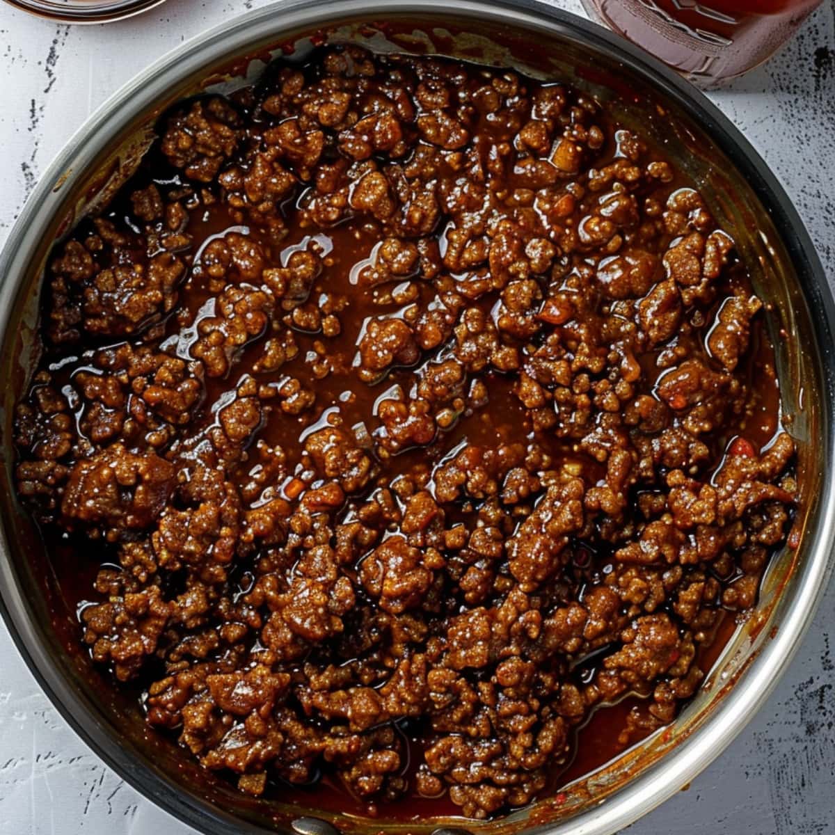 Cooked ground beef with BBQ sauce in a frying pan