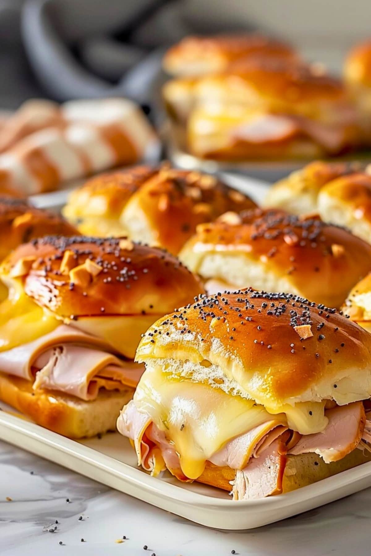 Turkey and cheese sliders on a tray.