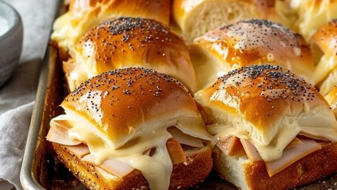 Turkey and cheese sliders on a baking tray.