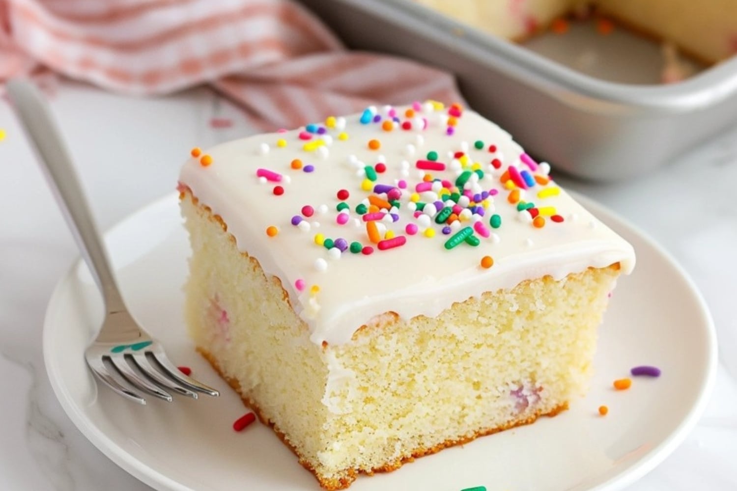 Vanilla sheet cake slice in a white plate.