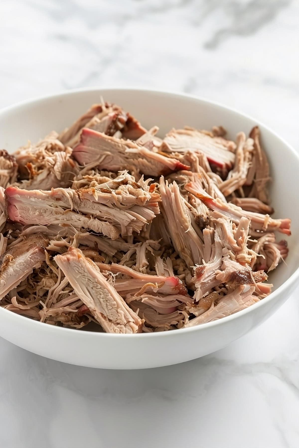 Air fried pulled pork in a white bowl.