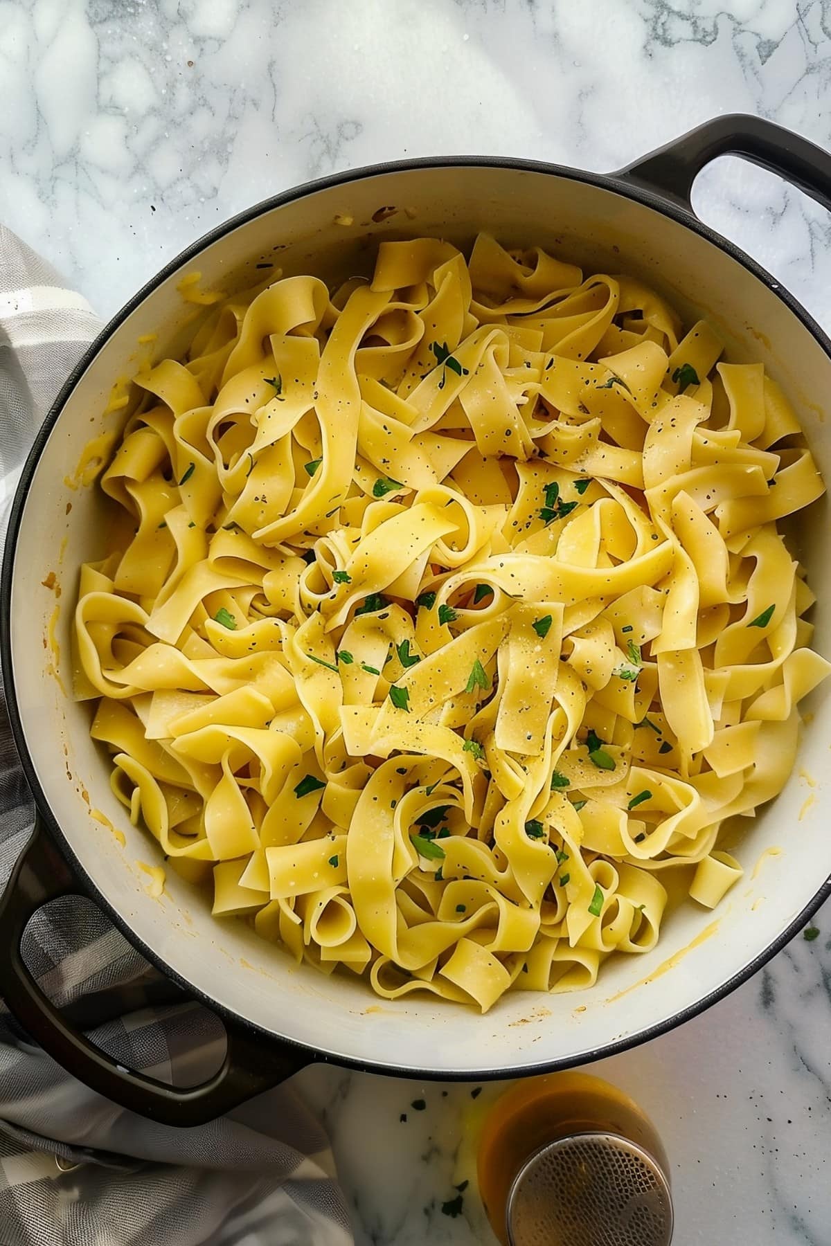 A large pot of rich and hearty Amish egg noodles with parsley, overhead view