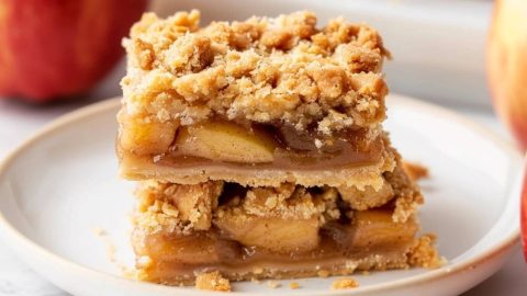 Apple bar slices stack on each other served on a white plate.