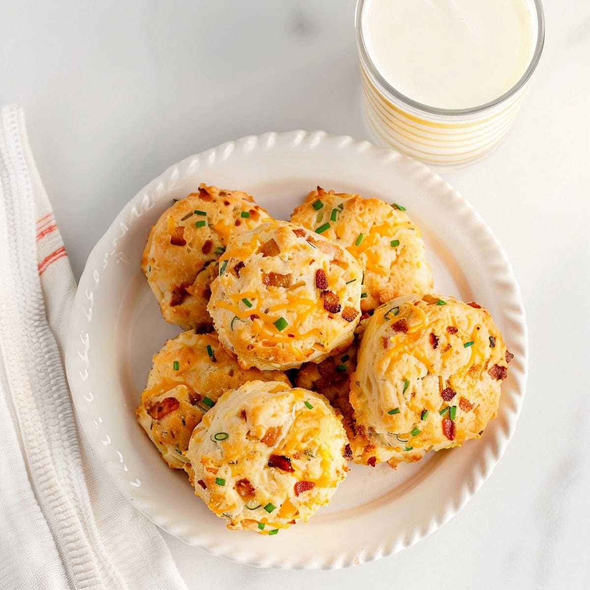 Homemade bacon cheddar biscuits on a plate, served with milk