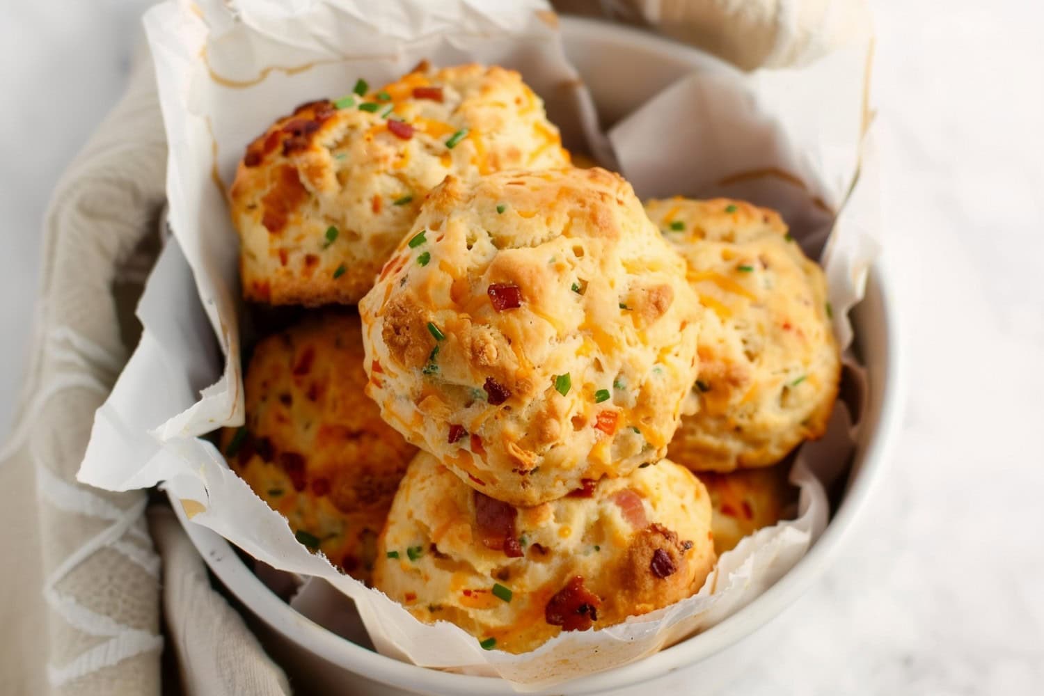 A bowl of homemade buttery and cheesy bacon cheddar biscuits
