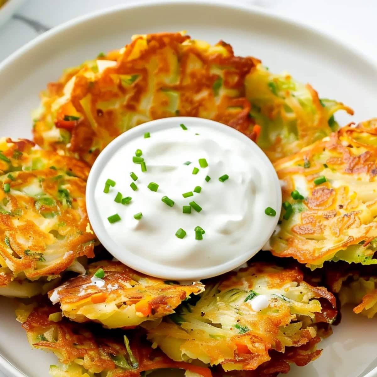 Delicious cabbage fritters with carrots and scallions, served hot and crispy with your favorite dipping sauce