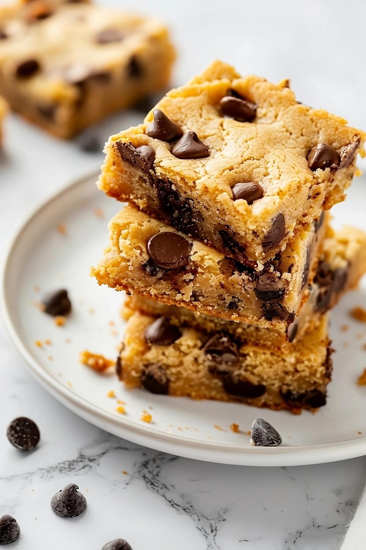 Cake mix chocolate chip cookie bars stacked on a plate.