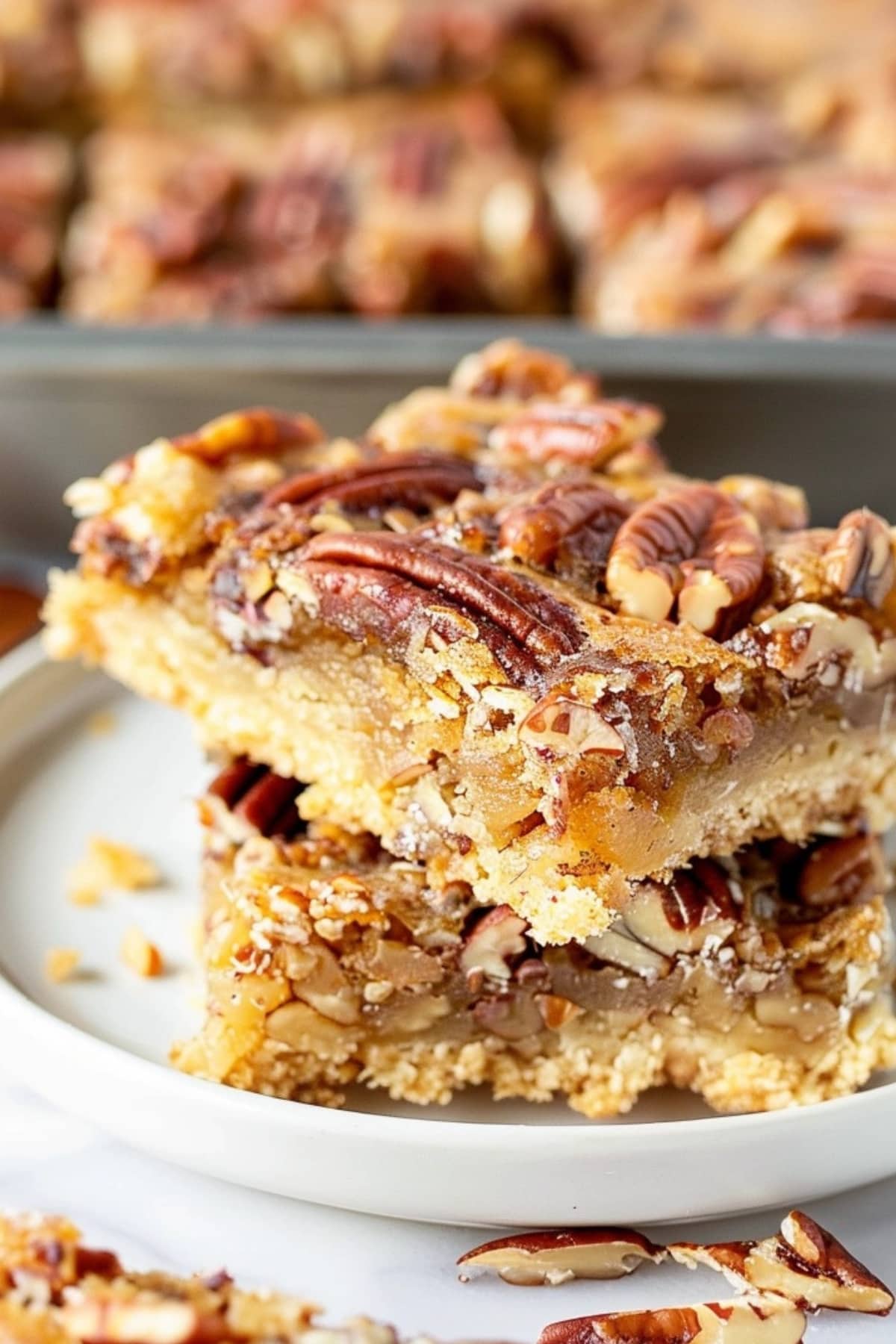 Slices of caramel pecan bars stacked on a white plate.