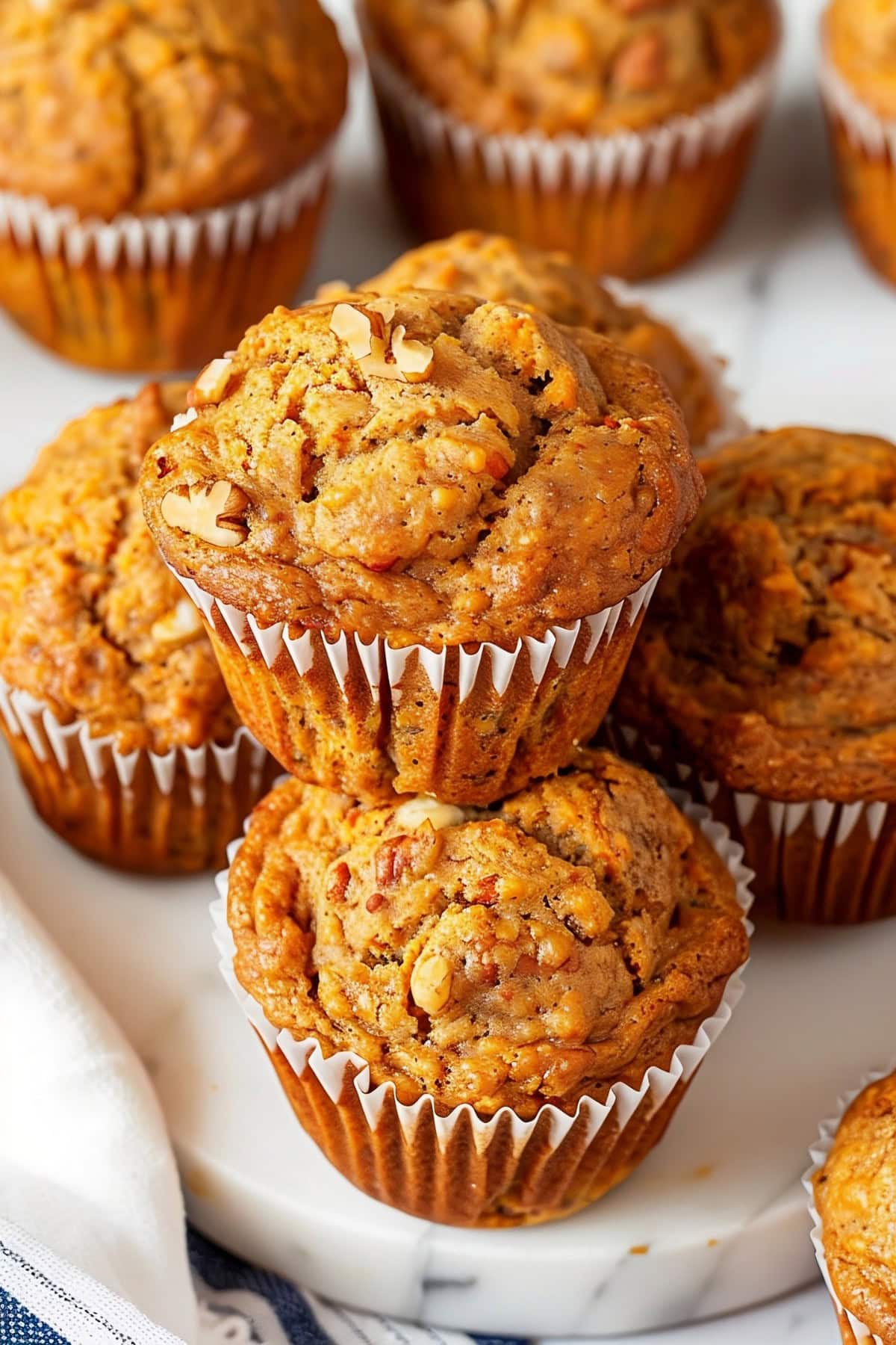 Carrot muffins with crushed nuts stacked on top of each other