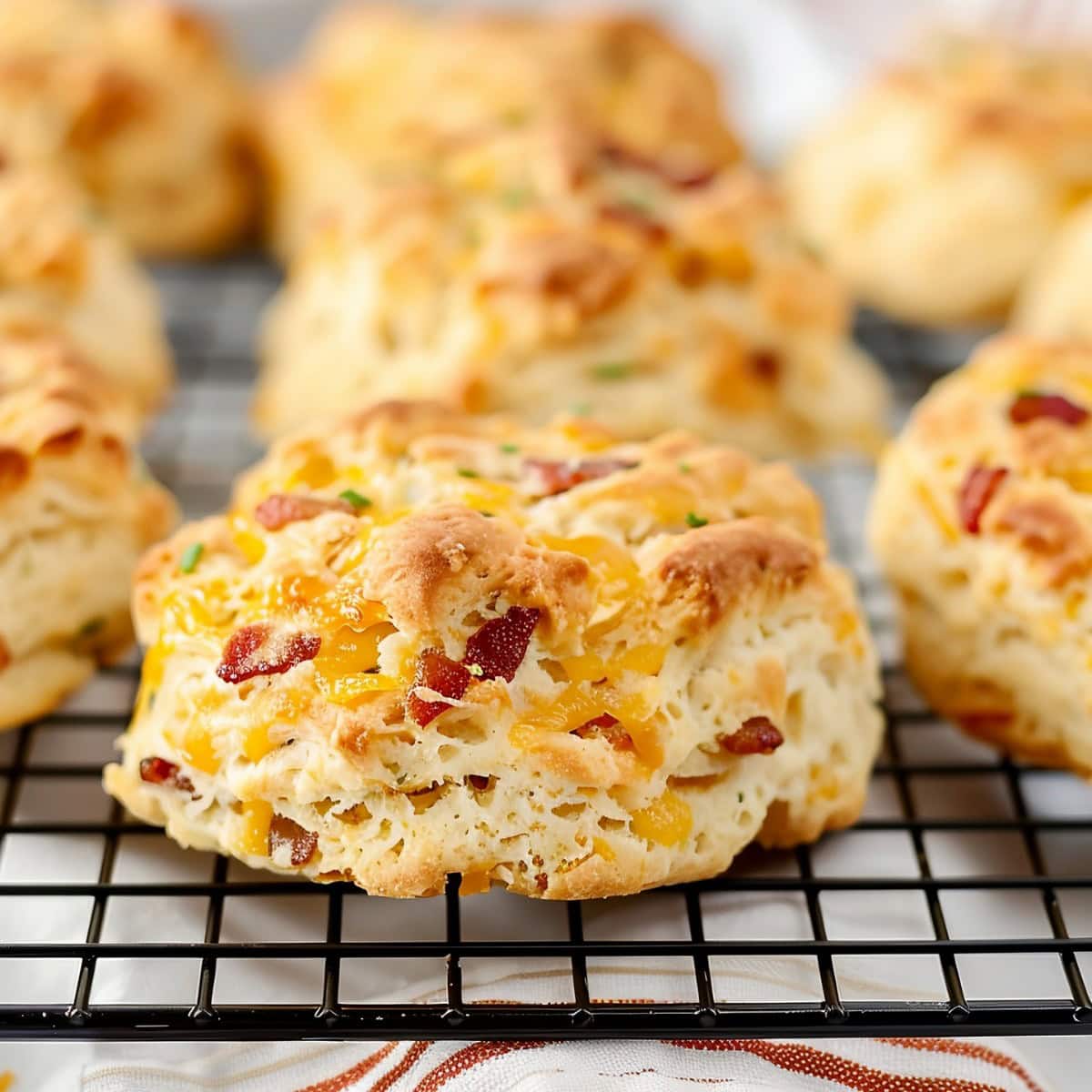 Bacon cheddar biscuits with chives on a cooling rack