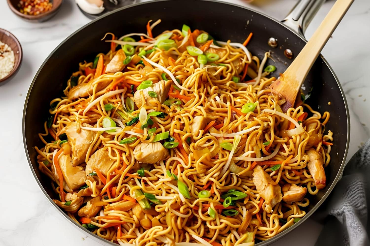 Chicken chow mein noodles with colorful vegetables in a pan