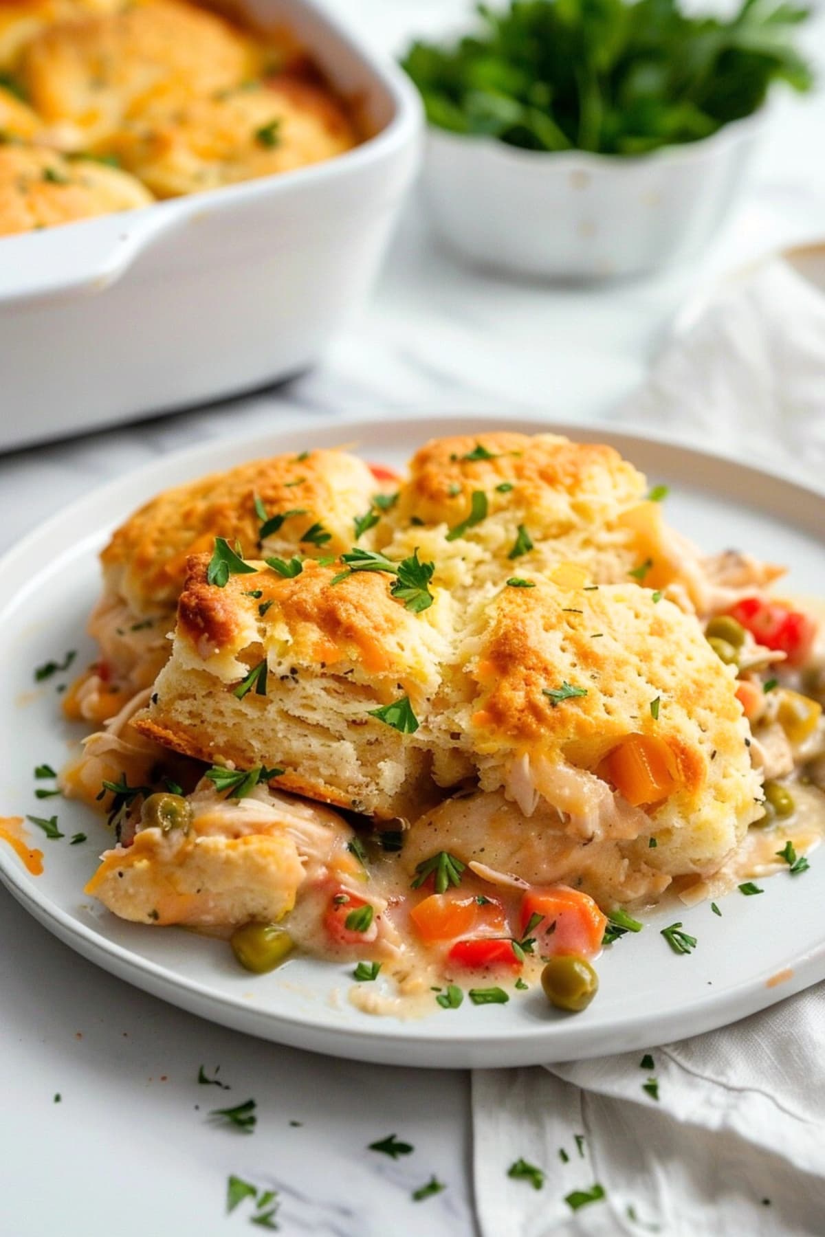 Serving of chicken and biscuit casserole in a white plate.