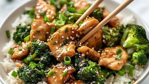 Chopsticks picking stir fry chicken and broccoli.