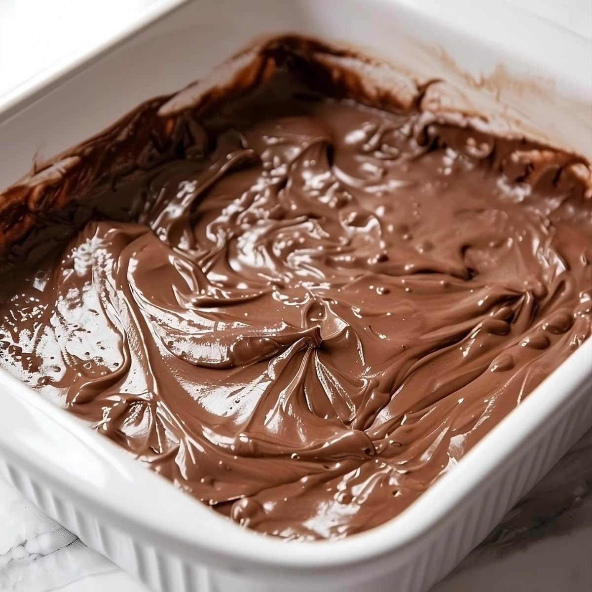 Chocolate batter spread in a baking dish.
