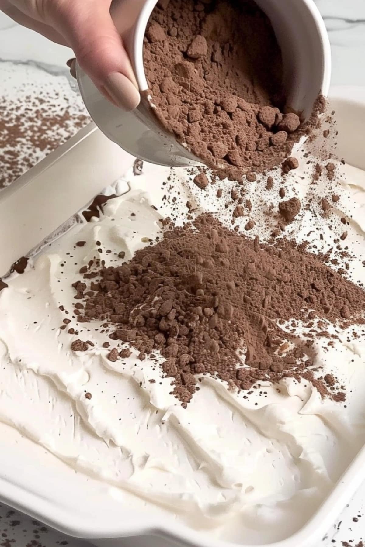 Chocolate cake mix poured on top of whipped cream.