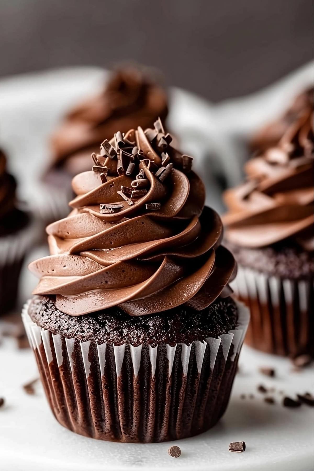 Close-up view of chocolate cupcake with chocolate frosting on top.