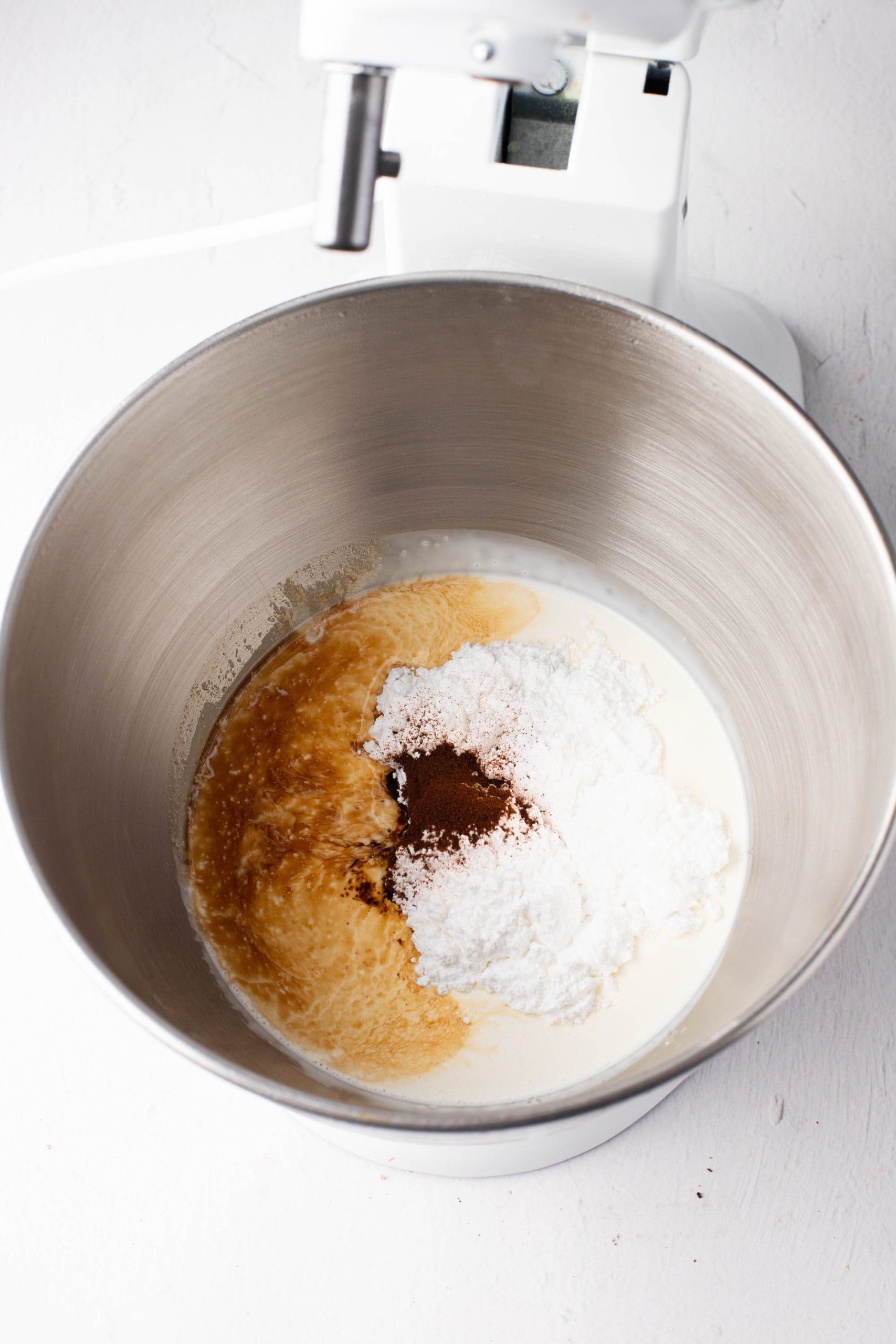 Heavy whipping cream, powdered sugar, instant espresso powder, vanilla extract in a mixing bowl.
