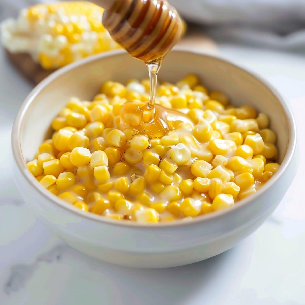 Bowl of creamy corn kernels dripped with honey