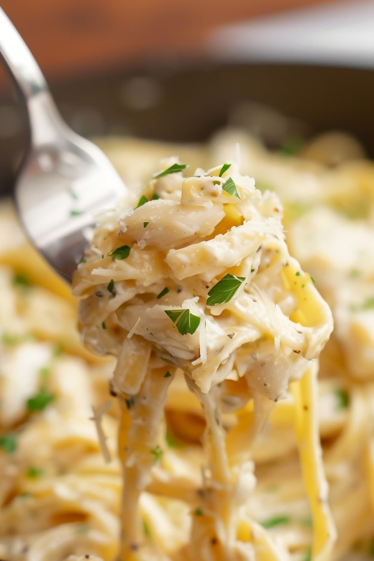 Savor the luxurious combination of delicate crab and smooth Alfredo sauce enveloping each strand of fettuccine served with a fork