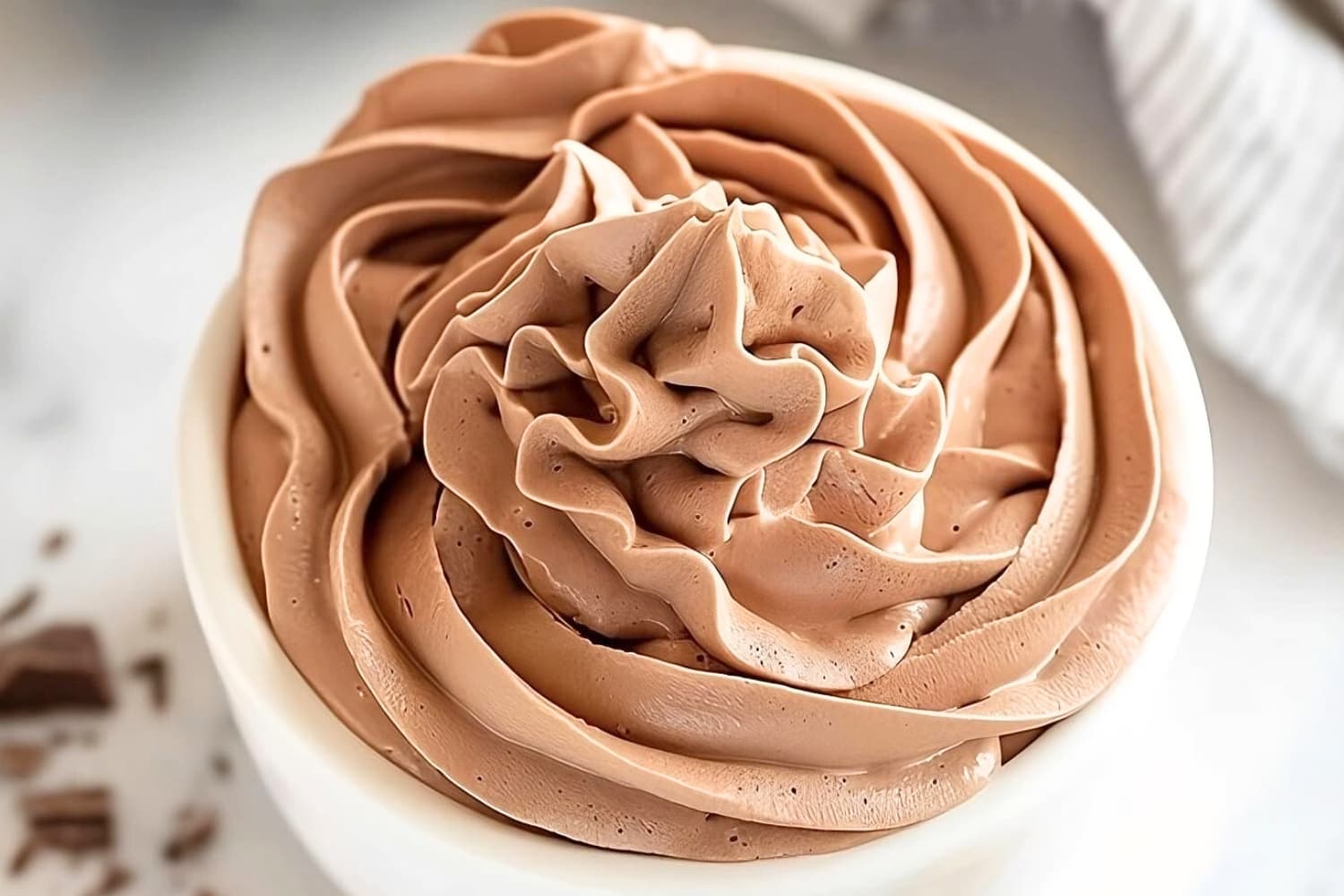 Creamy chocolate whipped cream in a small white bowl.