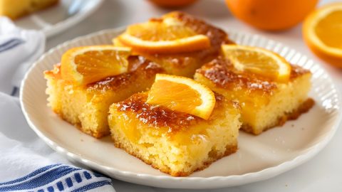 Close-up of a decadent slice of Greek orange cake, showcasing its moist crumb and citrus-infused aroma.