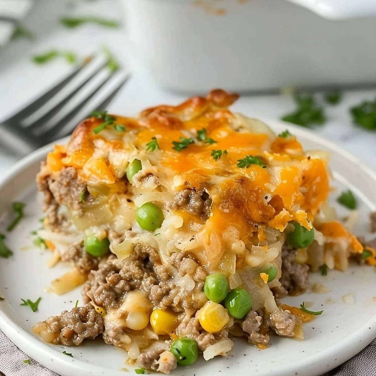 Close-up view of a slice of hamburger hashbrown casserole.