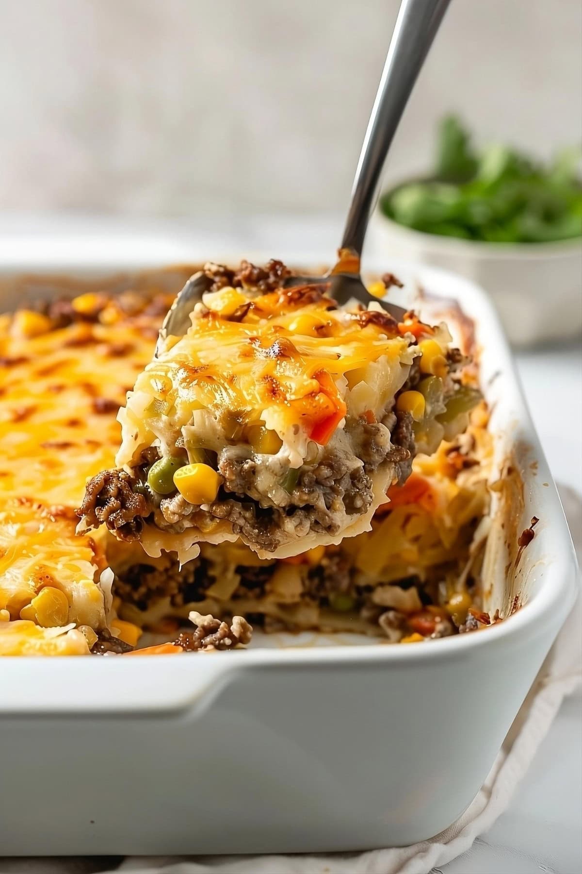 Close-up view of a slice of hamburger hashbrown casserole.