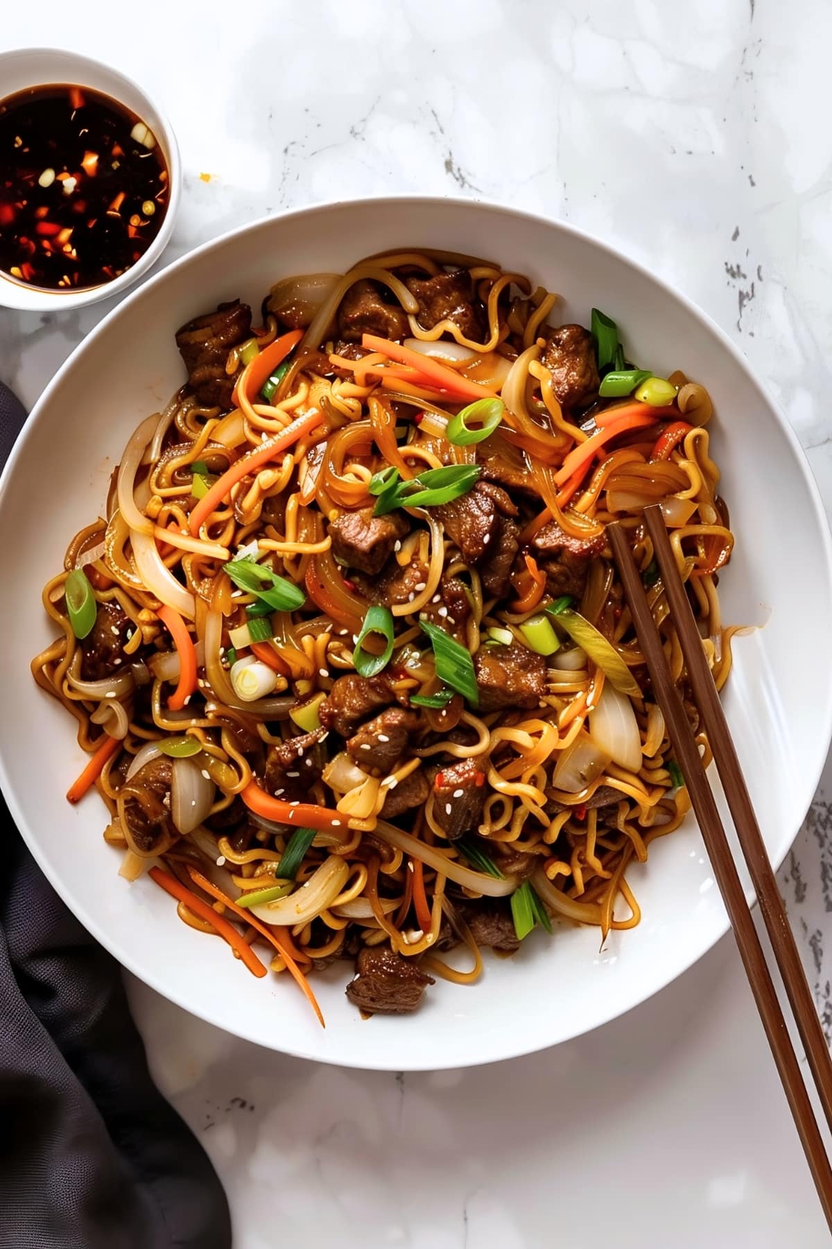 Bowl of homemade beef chow mein noodles with flank steak and stir-fried vegetables